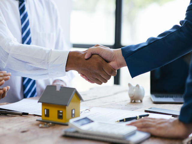 Close up shake hands, Considering buying a home, investing in real estate. Broker signs a sales agreement. agent, lease agreement, successful deal.